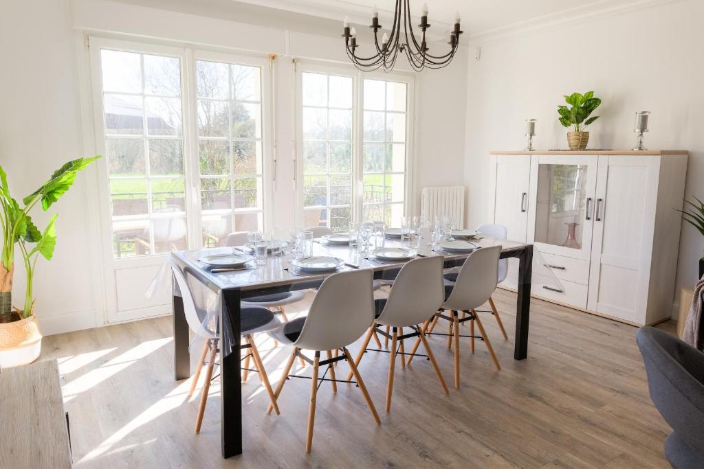 a dining room with a black table and chairs at Jolie maison pour 8 personnes in Plobannalec-Lesconil