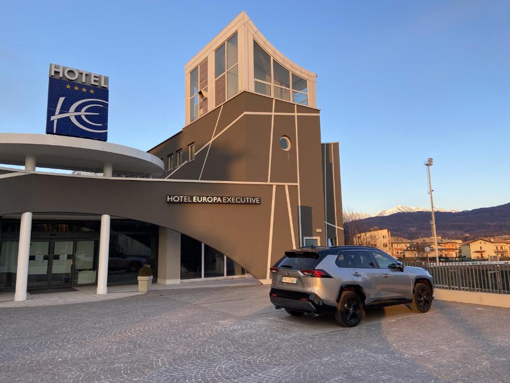 un'auto parcheggiata di fronte a un edificio di Hotel Europa Belluno a Belluno