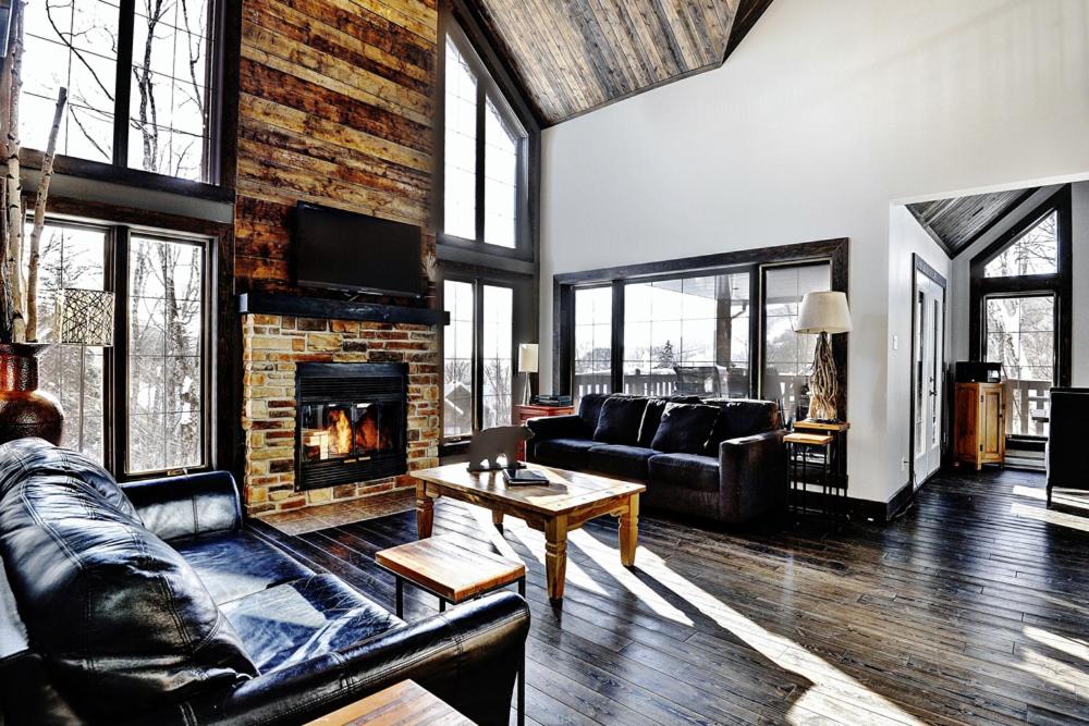 a living room with a couch and a fireplace at Chalet 02 Chemin Blanc by Les Chalets Alpins in Stoneham