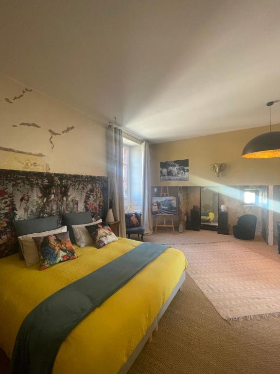 sypialnia z dużym żółtym łóżkiem w pokoju w obiekcie Maison Dada et SPA w mieście Meyssac