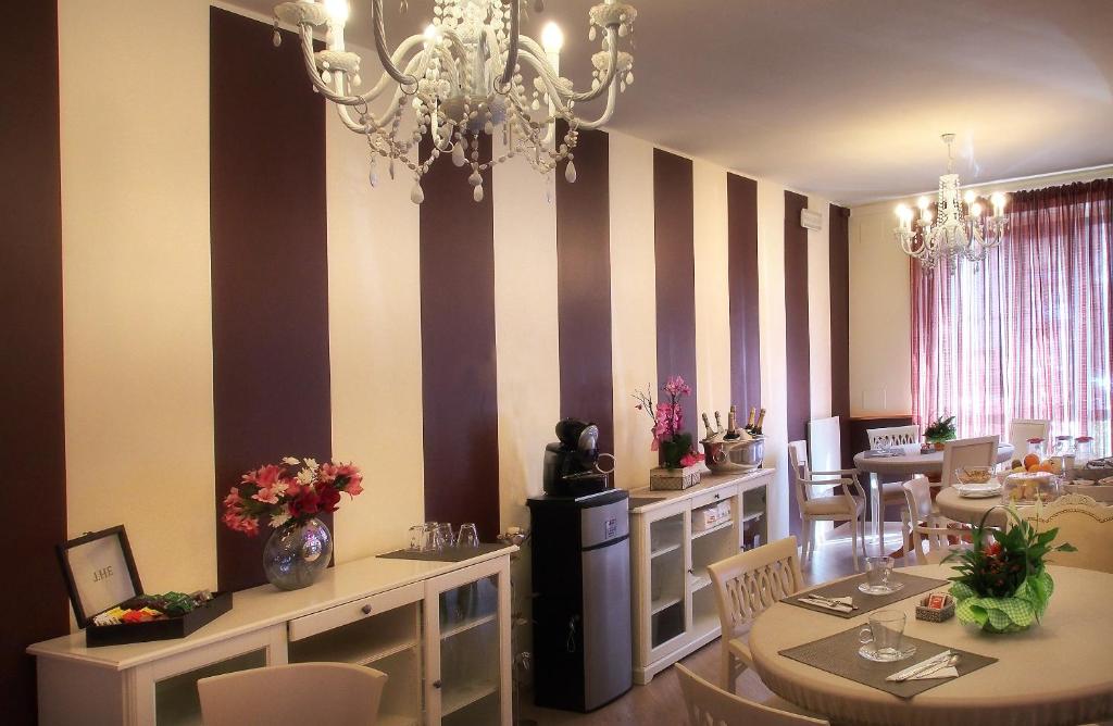 uma sala de jantar com mesas e cadeiras e um lustre em Hotel Due Spade em Fidenza