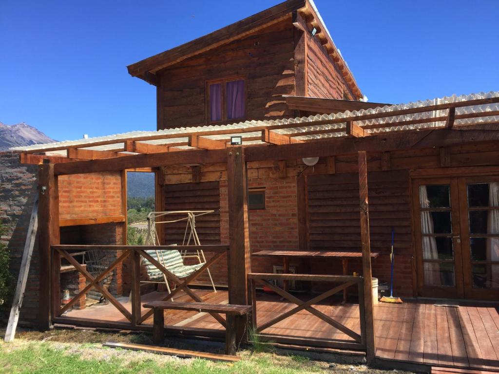 eine Blockhütte mit einer Veranda und einer Terrasse in der Unterkunft Cabaña Fer in Los Cipreses