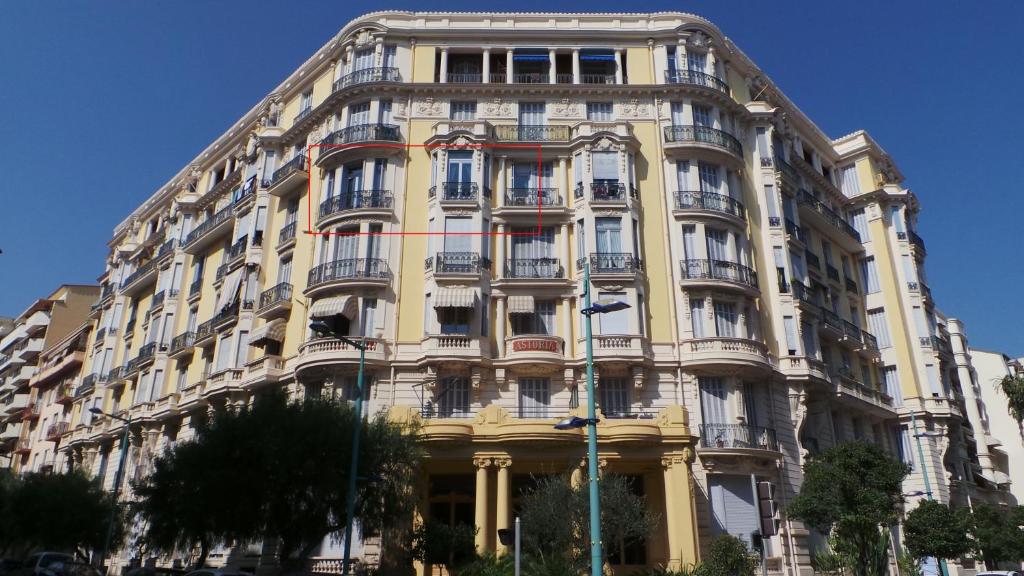 un grand bâtiment jaune avec balcon dans une rue dans l'établissement 2 pièces, Centre Ville, 50 mètres plages et mer., à Menton