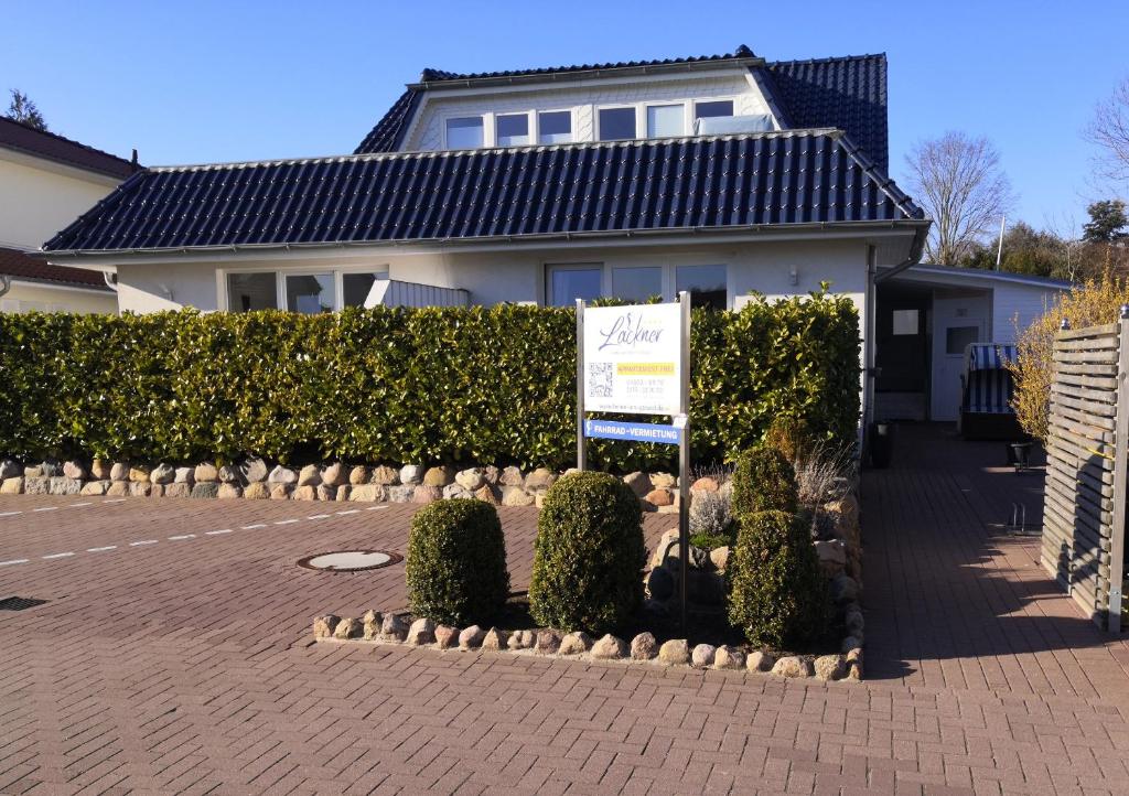 a house with a sign in front of a yard at Haus Lackner in Timmendorfer Strand