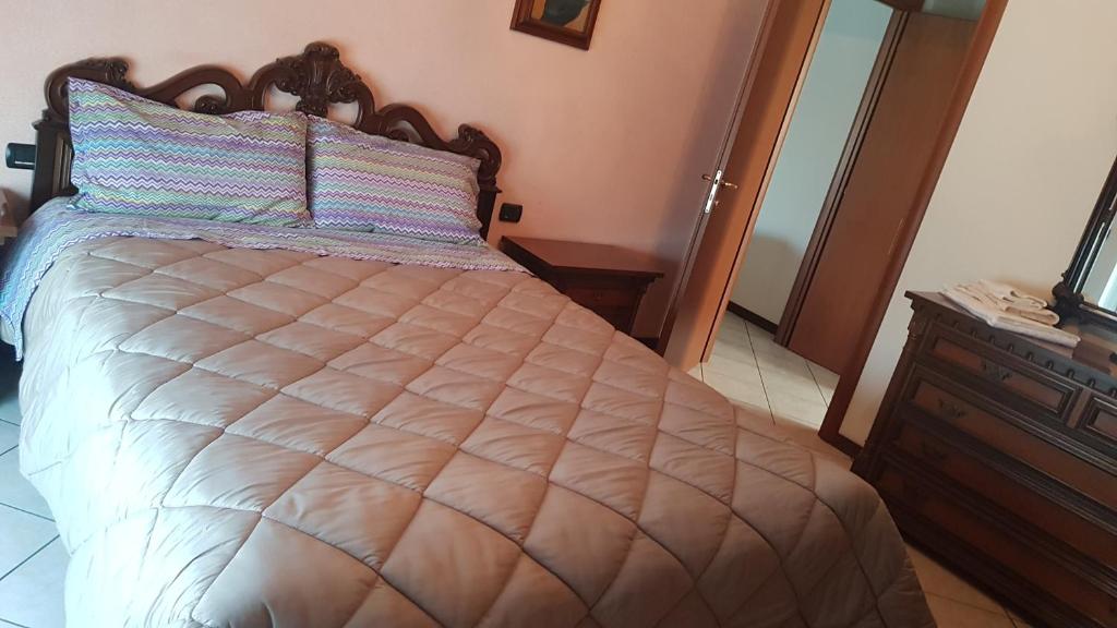 ein Schlafzimmer mit einem Bett, einer Kommode und einem TV in der Unterkunft Iris in Cislago