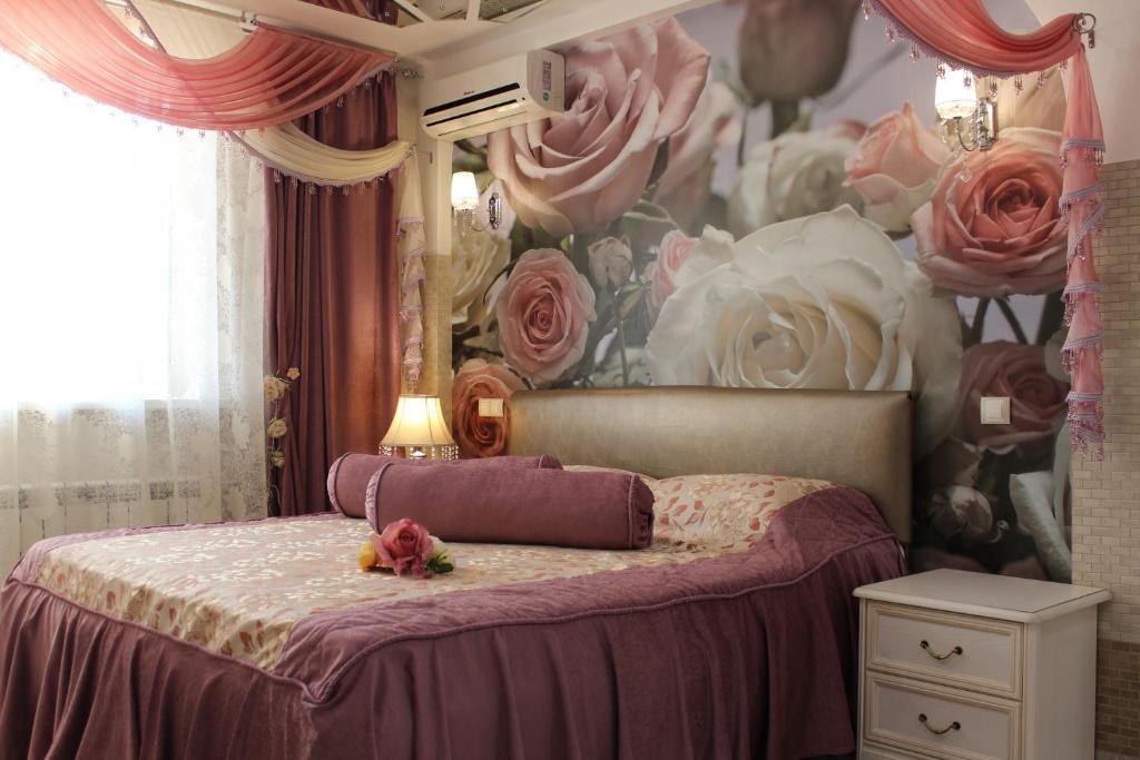 1 dormitorio con 1 cama con un mural de rosas en Natali Luxury Apartments, en Voronezh