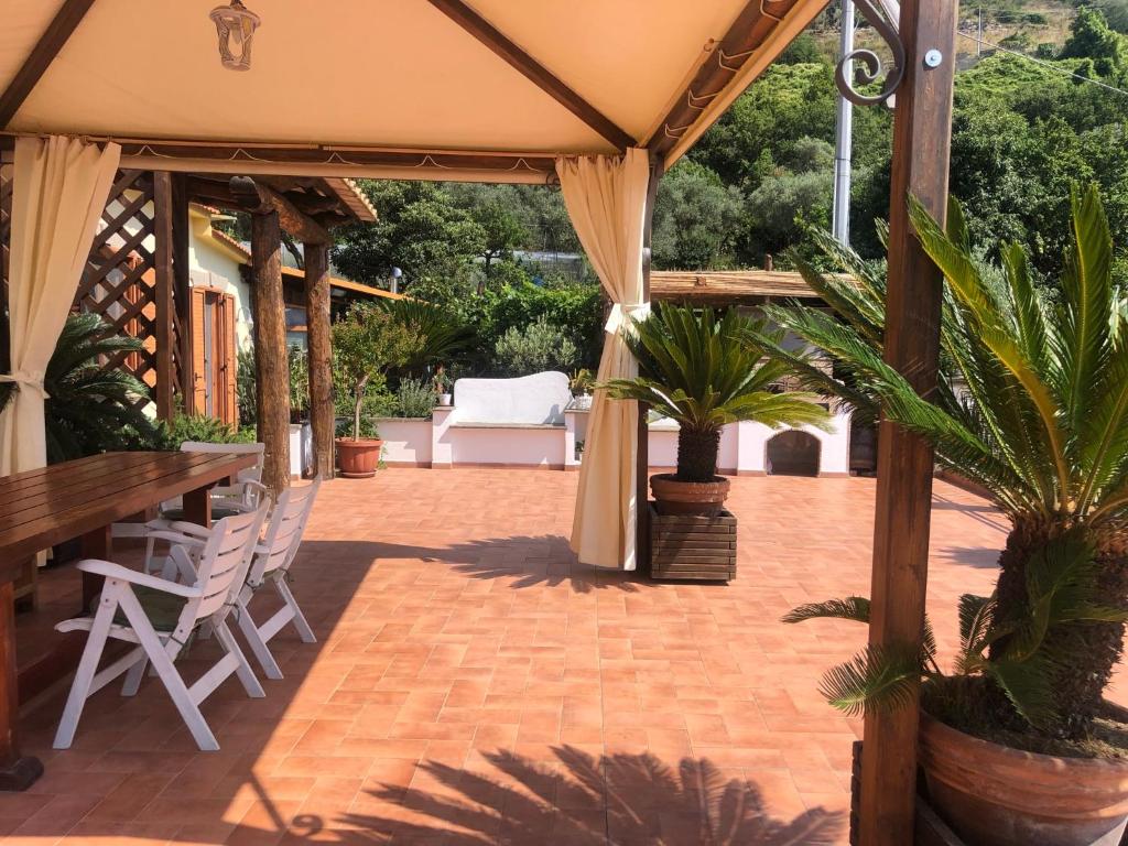 een patio met een tafel en stoelen en palmbomen bij Donna Caterì in Termini