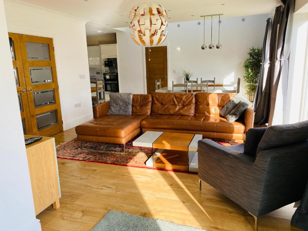 een woonkamer met een bank en een tafel bij Mayors House Ideal for Groups & Business in Peterborough