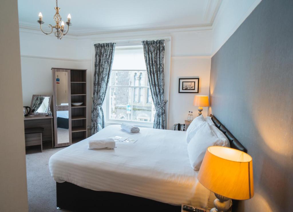 a bedroom with a large bed and a window at Johnny Dough's Conwy with Rooms in Conwy