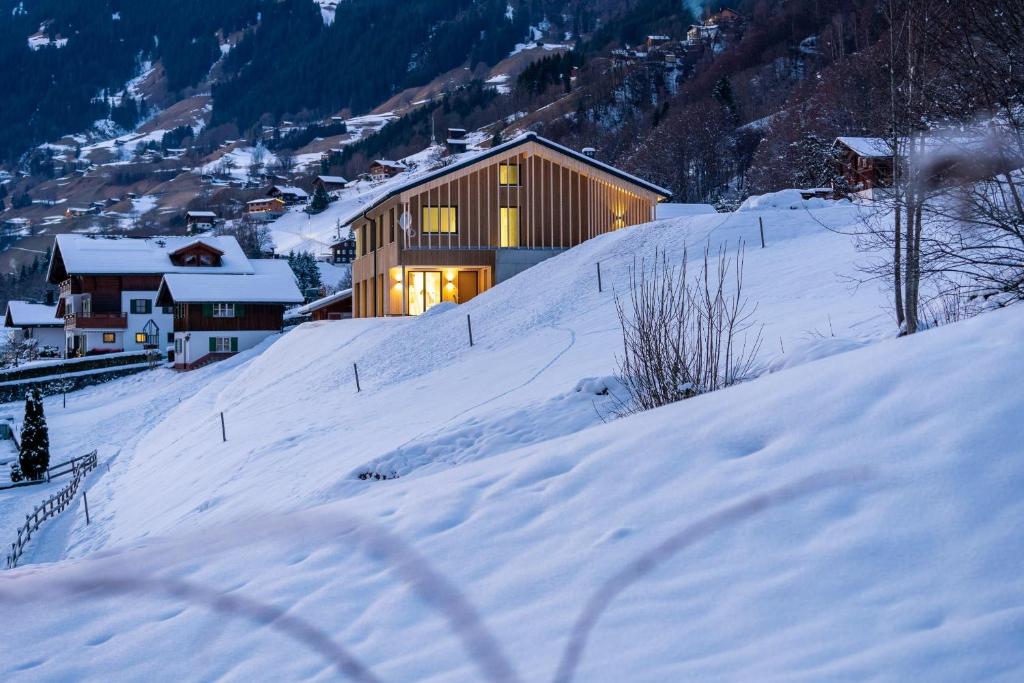 a building on a snow covered hill with snow at Apartment Fitsch in Silbertal