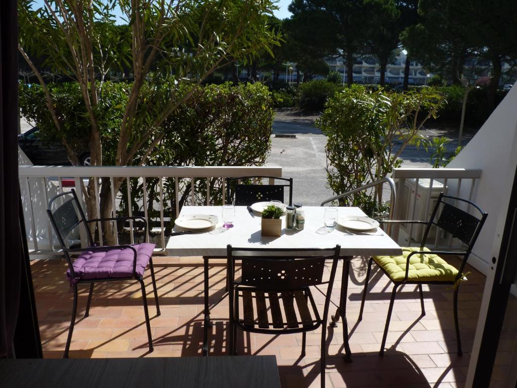 une table et des chaises assises sur un balcon dans l'établissement Sol-y-Days Flamant, Studio avec terrasse et parking, résidence avec un accès direct à la plage, au Grau-du-Roi
