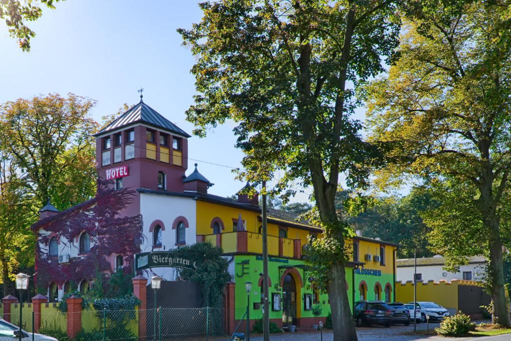 ein farbenfrohes Gebäude mit einem Turm darüber in der Unterkunft Waldschlösschen in Mittenwalde