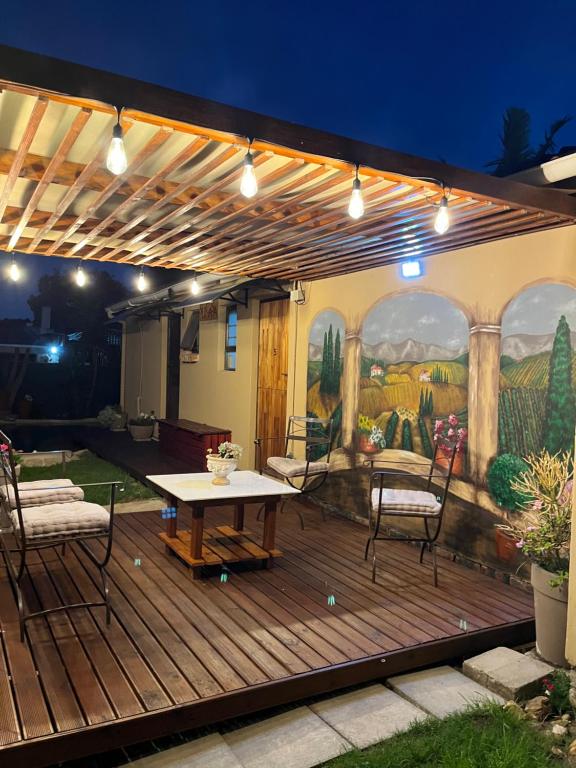 a deck with a table and chairs and a painting at SU CASA B&B in Springfield