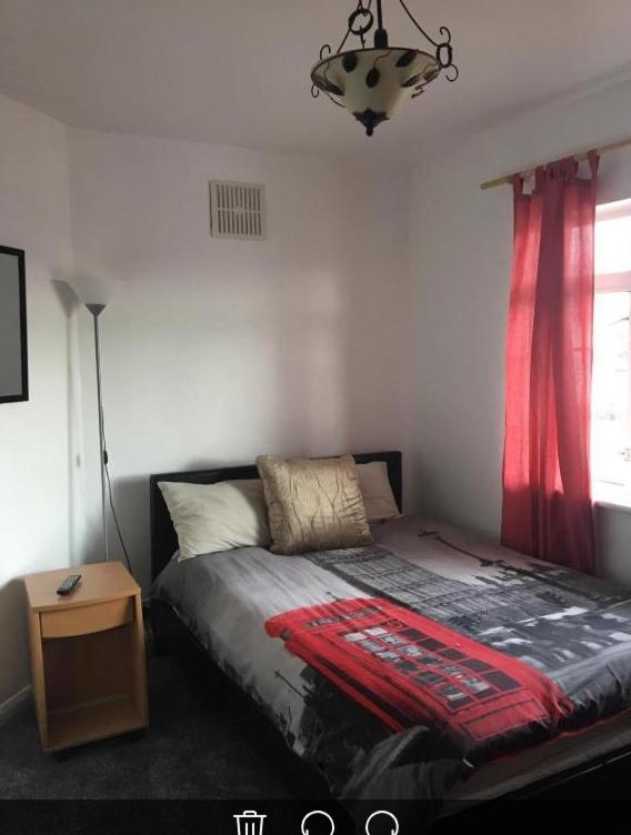 a bedroom with a bed with a red curtain at Save Money BOOK NOW! in Hatfield