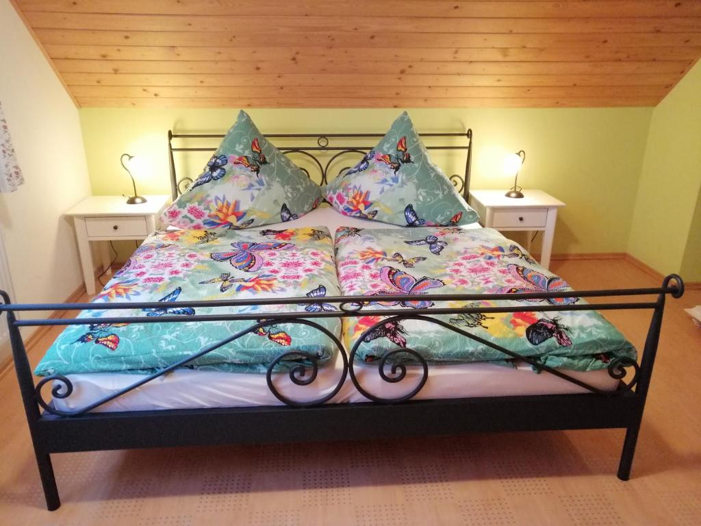 Una cama con sábanas y almohadas coloridas. en Schaffrath´s - Ferienhaus, en Hohnstein