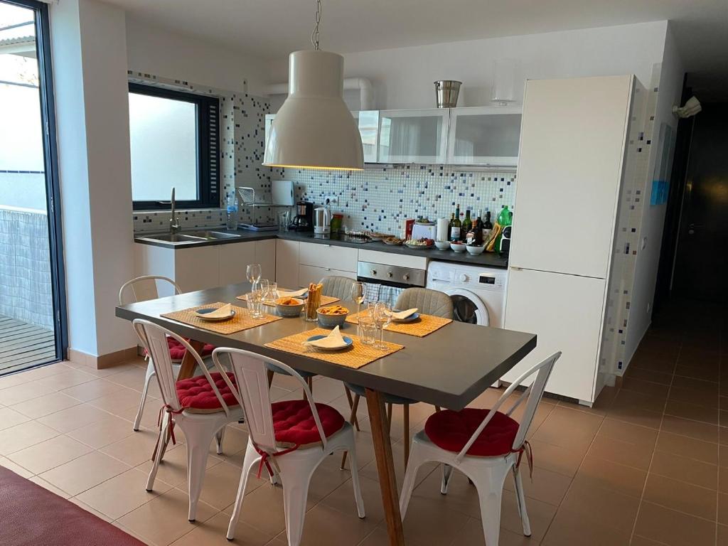 een keuken met een tafel en stoelen met wijnglazen bij vista oceano, confortevole, ampio, gran terrazza, Wi-Fi in Costa Calma