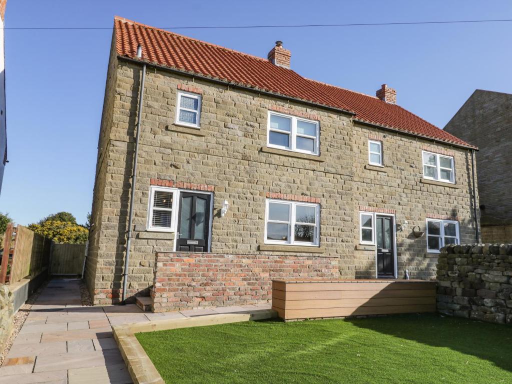 a brick house with a lawn in front of it at Old Peak in Scarborough