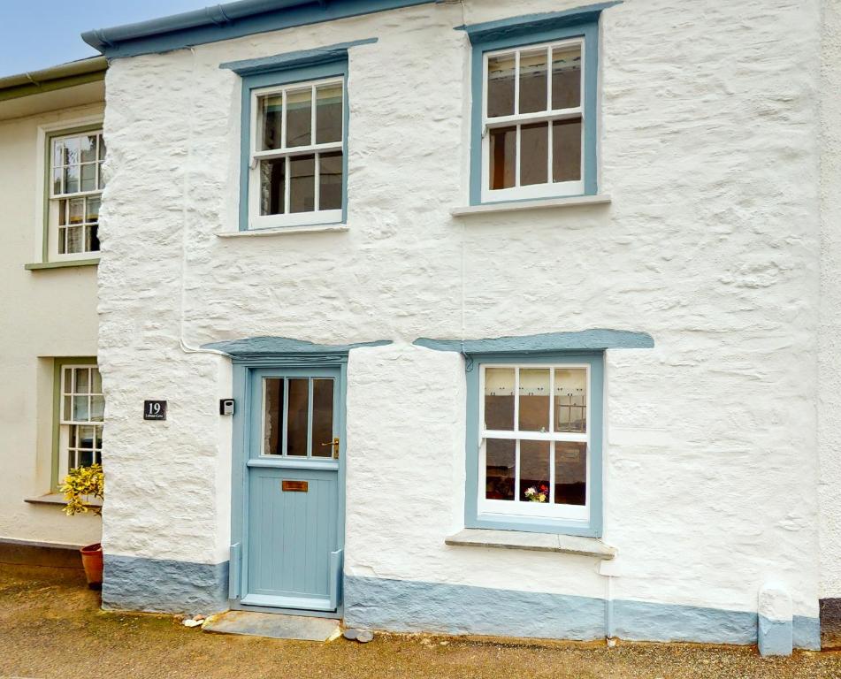 a white house with blue doors and windows at Lobster Cove, 50 yards from the sea in Port Isaac