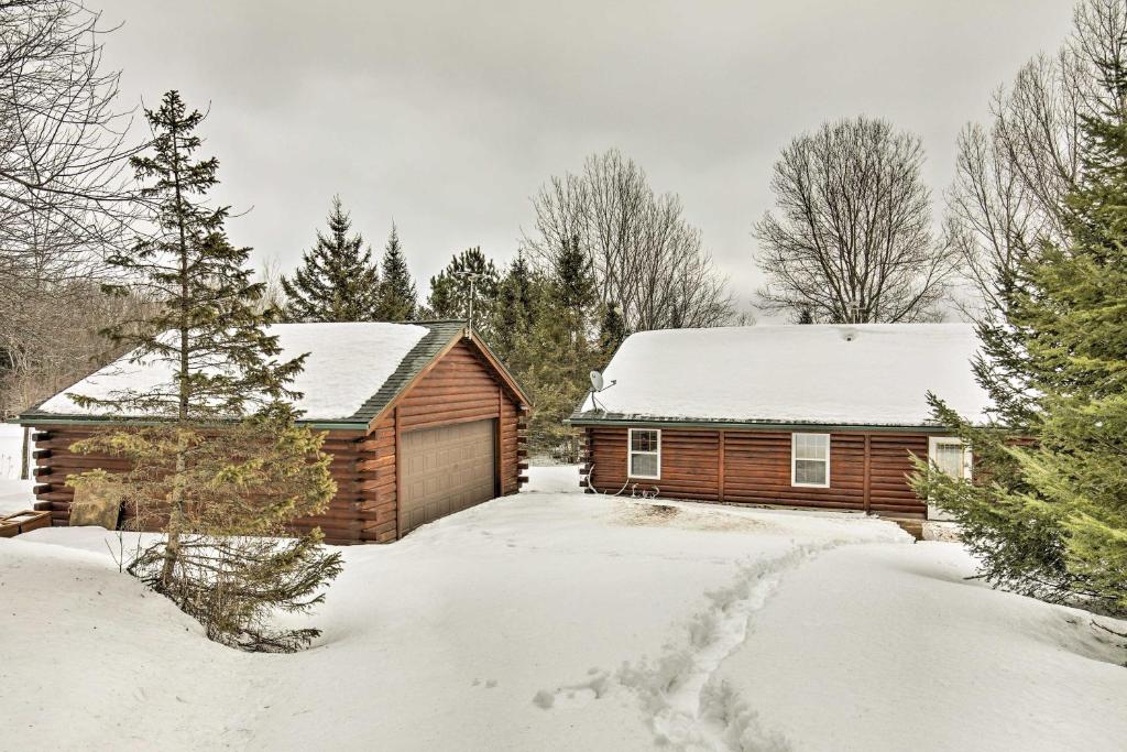 a log cabin in the snow in a yard at Lakefront Phelps Cottage with Private Boat Dock in Phelps