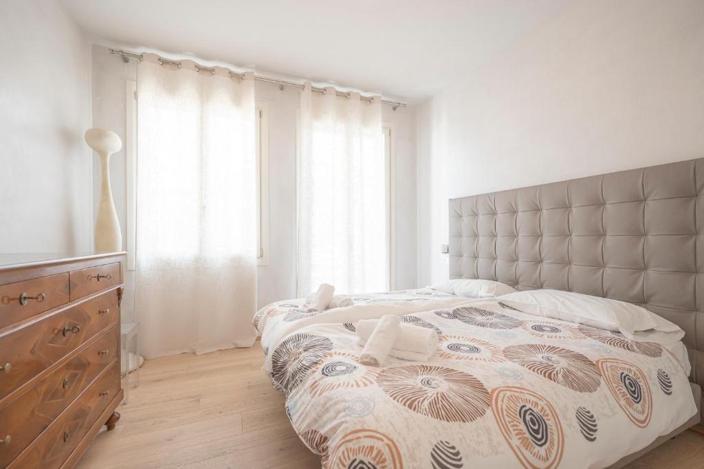 a bedroom with a bed and a dresser and a window at Attico incantevole con Jacuzzi idromassaggio e sauna in Treviso