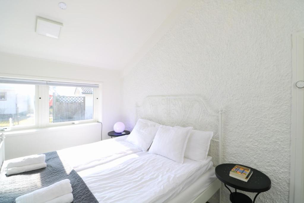 a white bedroom with a white bed and a window at Bright & Spacious Apartment in Kinna Center in Kinna