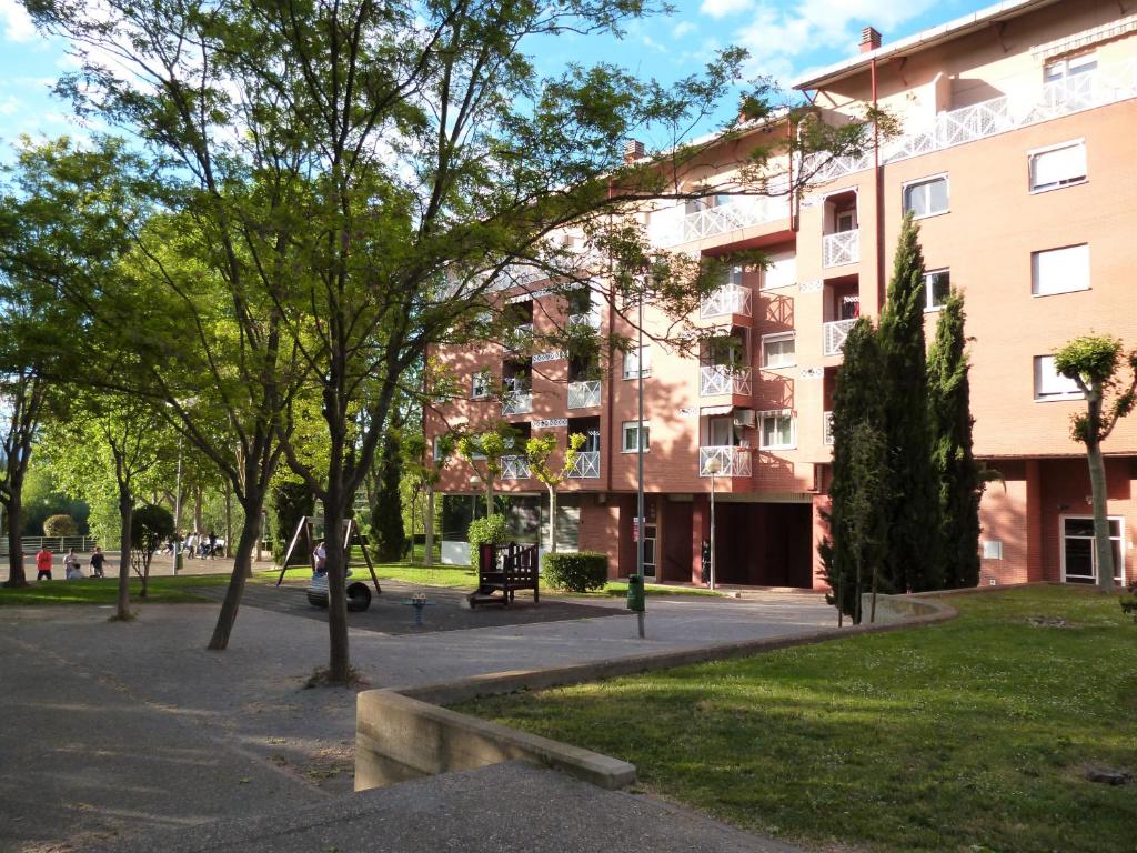 a building with a park in front of it at Logrocity Puerta del Ebro Parking privado gratis in Logroño