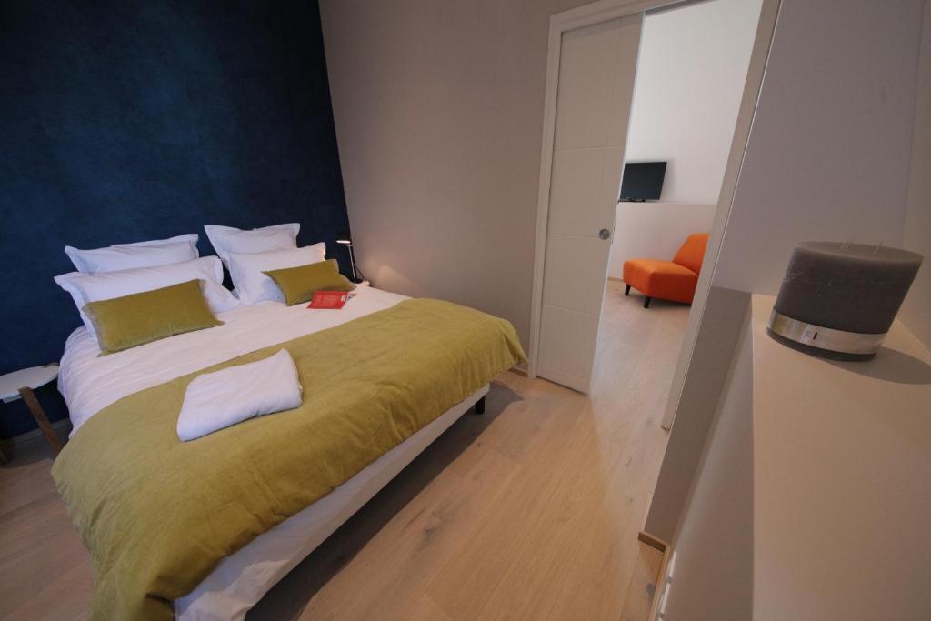 a bedroom with a large bed with a green blanket at Villa Saint Enogat in Aix-les-Bains