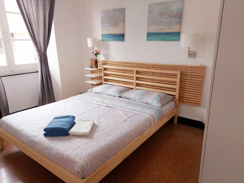 um quarto com uma cama grande e uma cabeceira em madeira em BRIGNOLE E em Gênova