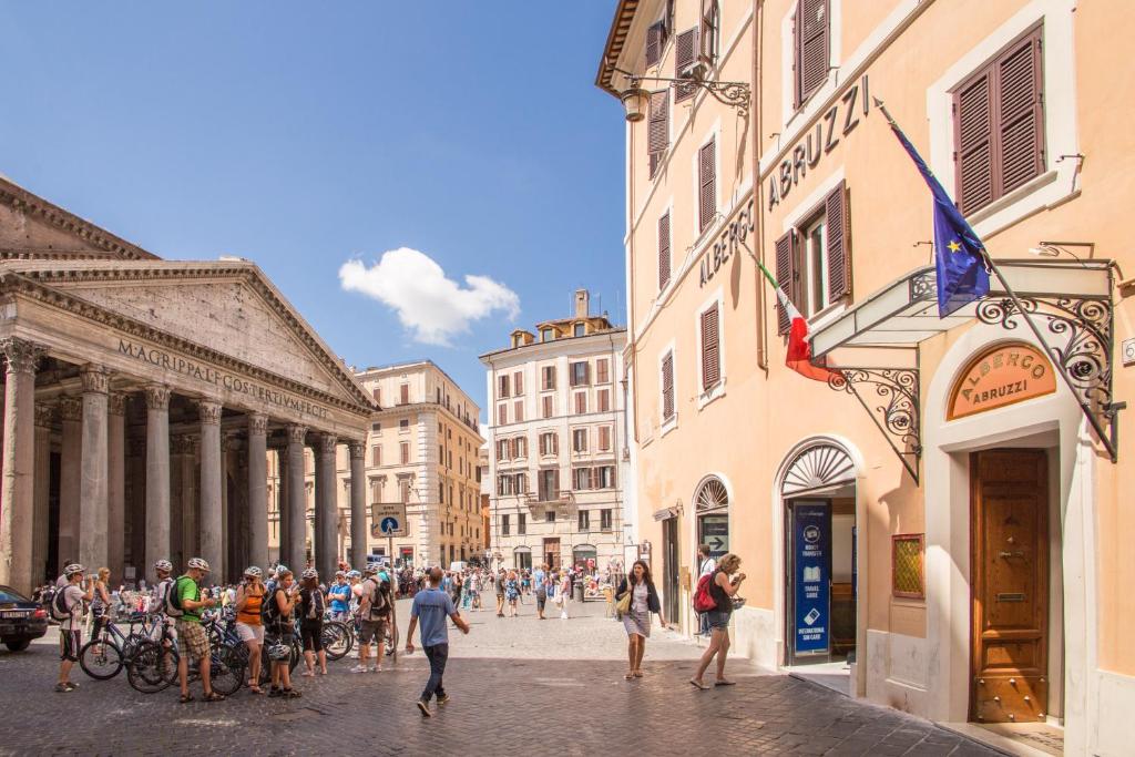 Un gruppo di persone che camminano per una strada cittadina di Albergo Abruzzi a Roma