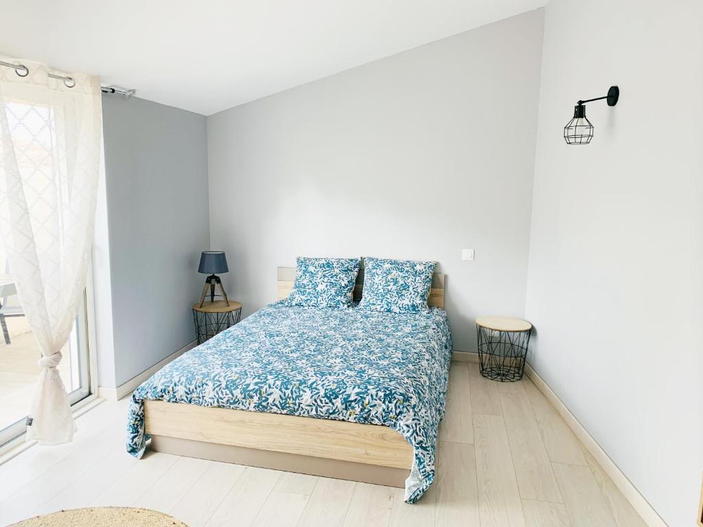 1 dormitorio con 1 cama con edredón azul en Maison de village au cœur de la Drôme Médiévale - Les Remparts - Drôme provençale, en Châteauneuf-du-Rhône