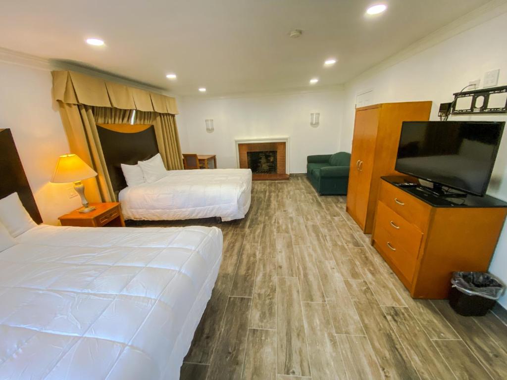 ein Hotelzimmer mit zwei Betten und einem Flachbildfernseher in der Unterkunft Town and Country Inn in Santa Barbara