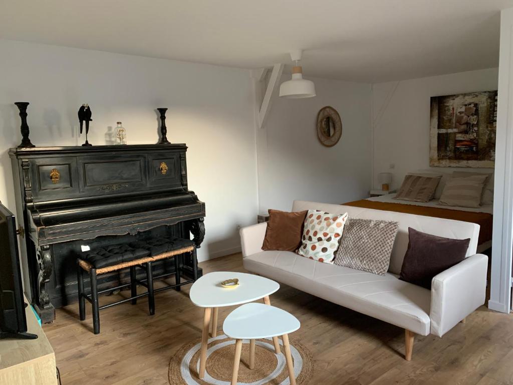 sala de estar con sofá y piano en Dom’s Garden, en Livarot