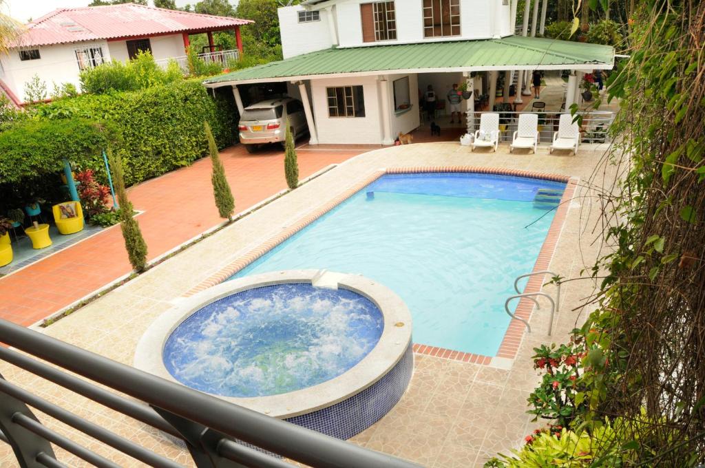 a large swimming pool in front of a house at Zarabanda Campestre - Moderna Casa Campestre para alojamiento y eventos in Tuluá