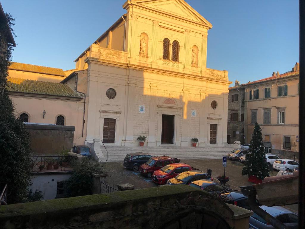 une église avec des voitures garées dans un parking dans l'établissement Fronte Duomo, à Tarquinia