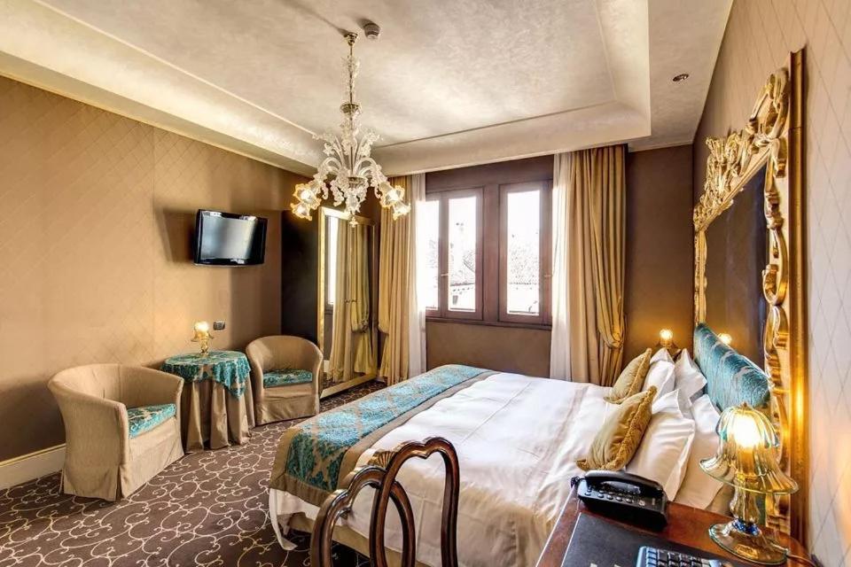 a hotel room with a large bed and a table at Pesaro Palace in Venice