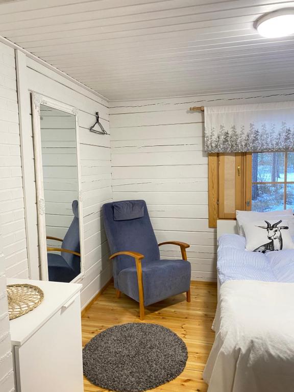 a bedroom with a bed and a blue chair at Playa del Finland in Peräseinäjoki