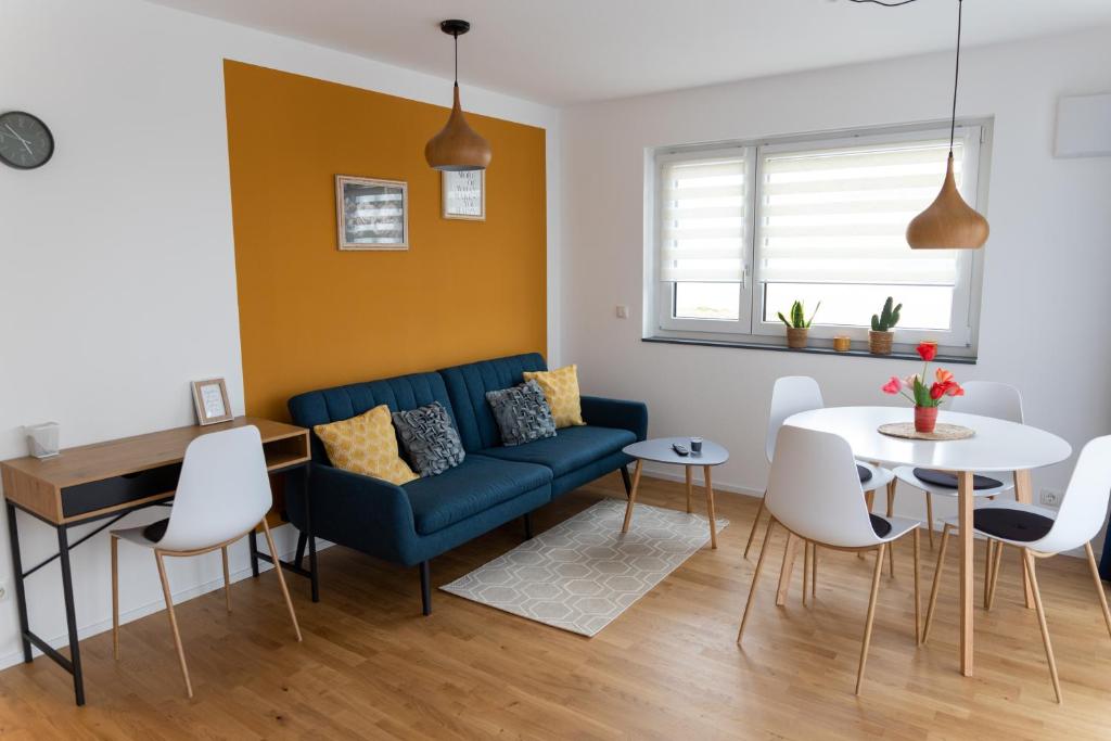 a living room with a blue couch and a table at FeWo Aurora am Bodensee in Friedrichshafen