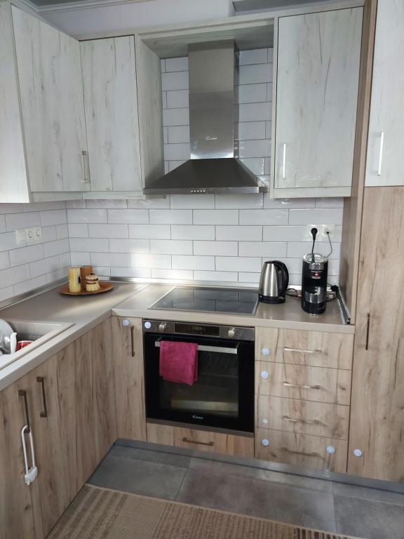 a kitchen with wooden cabinets and a stove top oven at EVA'S HOME in Kefalos