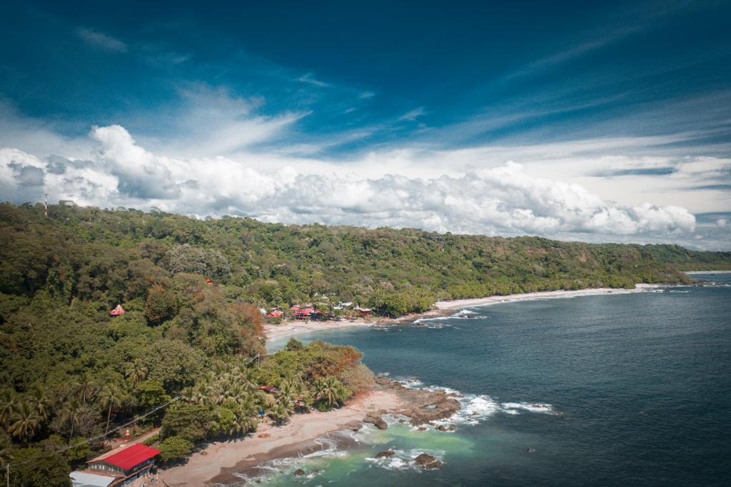 uma vista aérea de uma praia com árvores e água em Hotel El Jardin em Montezuma