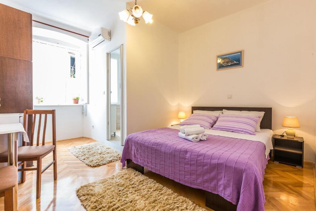 1 dormitorio con 1 cama con colcha púrpura en Mila apartments in old town centre, en Zadar