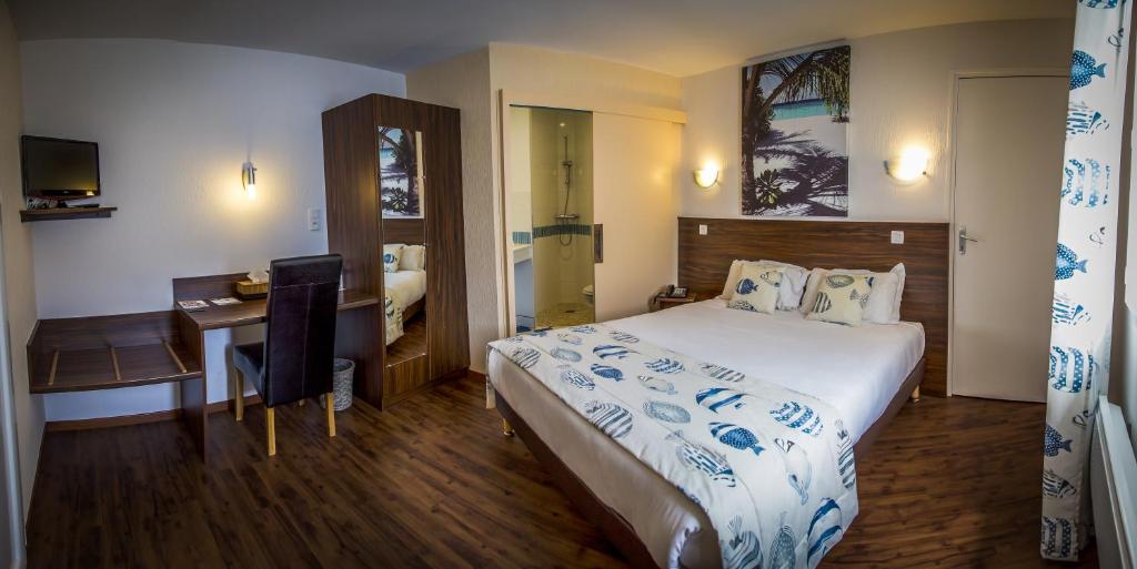 Habitación de hotel con cama grande y escritorio. en Brit Hotel Azur, en Saint-André-de-la-Marche