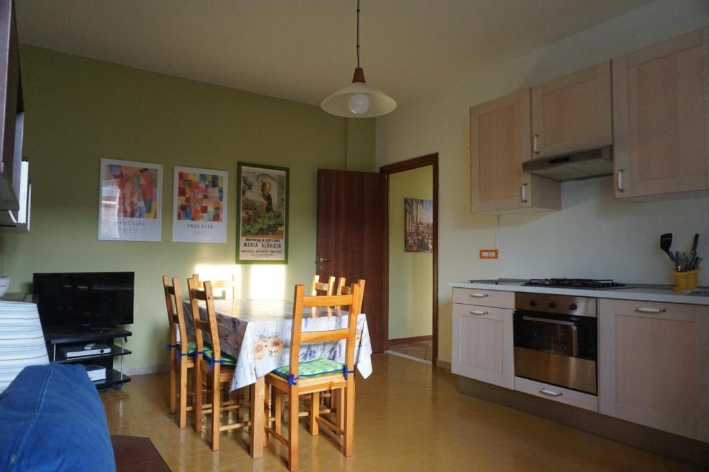 uma cozinha com mesa e cadeiras e uma cozinha com fogão em Appartamento con Giardino em Levanto