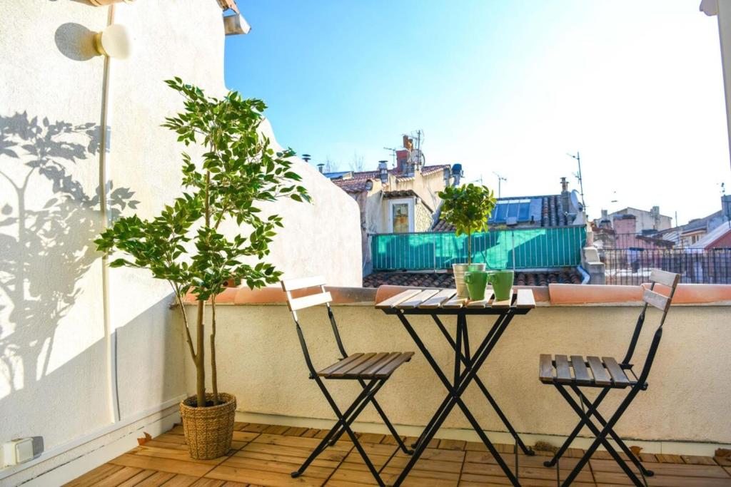 マルセイユにあるLe Duplex - Terrasse au cœur de Marseille Panierのバルコニー(テーブル、椅子2脚付)