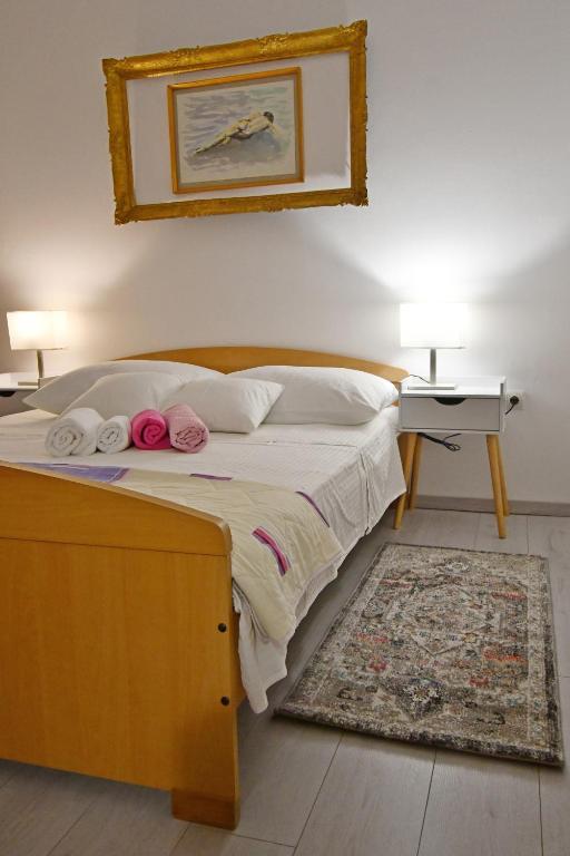a bedroom with a bed with two lamps and a rug at apartmani Novotny- žuti in Rab