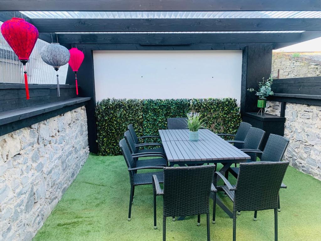 a patio with a table and chairs and red balloons at Bright 3bed sleeps 9 with secret garden 5min walk to town in Sligo