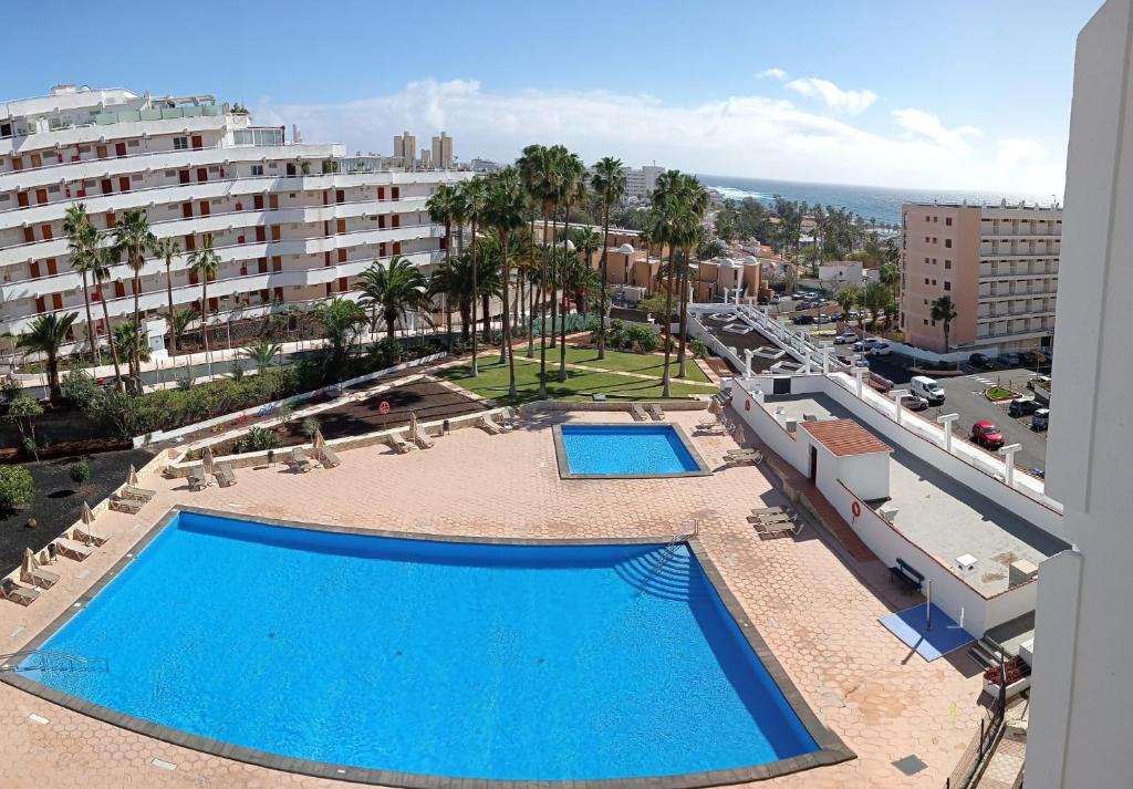 - une vue sur deux piscines depuis un bâtiment dans l'établissement Playa de las Americas Seaview Viñadelmar, à Playa de las Americas