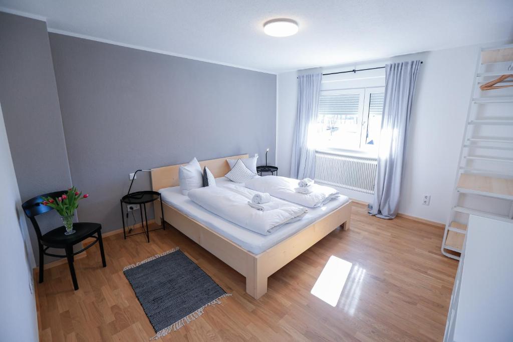 um quarto com uma cama branca e uma janela em WOHNUNG OBERGESCHOSS mit 3 Schlafzimmer in ruhiger Gegend em Mäder