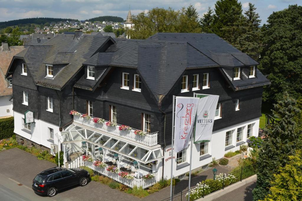 ein großes schwarzweißes Gebäude mit schwarzem Dach in der Unterkunft Hotel zum Kreuzberg in Winterberg