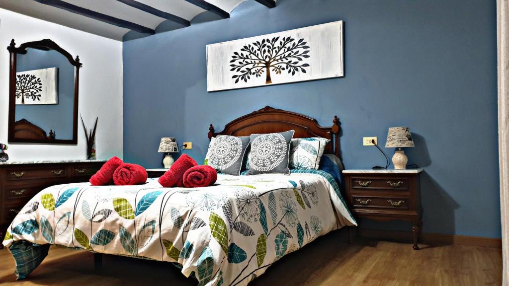 a blue bedroom with a bed with red pillows at Casa Castillo de la Estrella in Segorbe