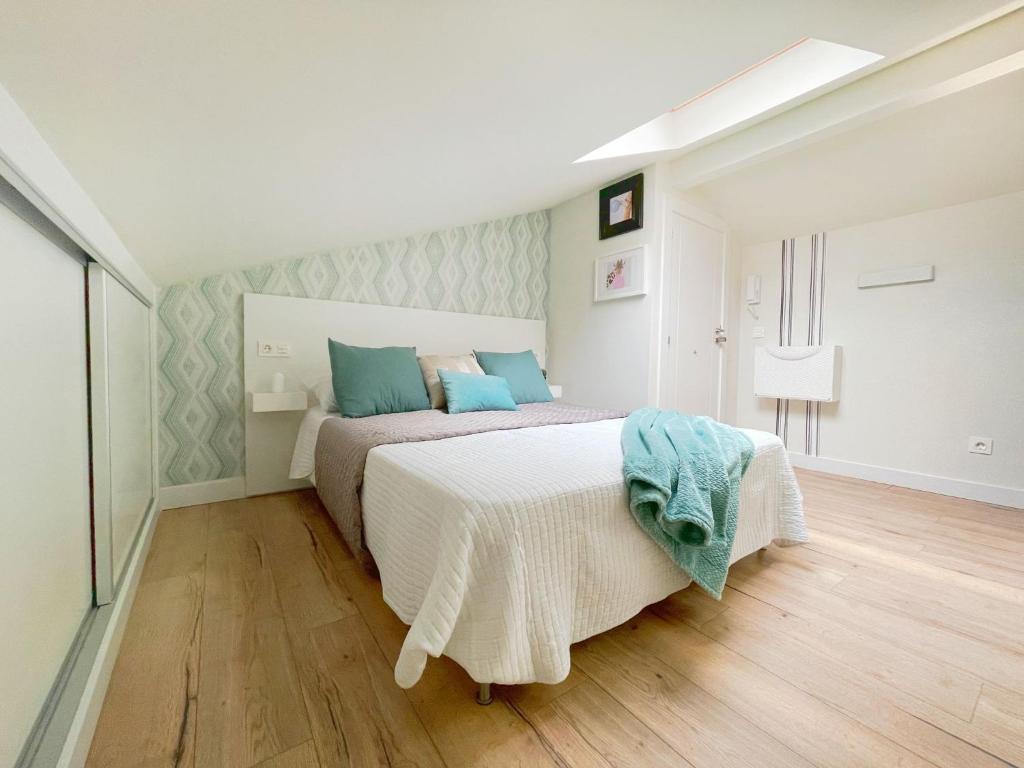 um quarto com uma cama grande e almofadas azuis em Apartamento Milo Ordoño em León